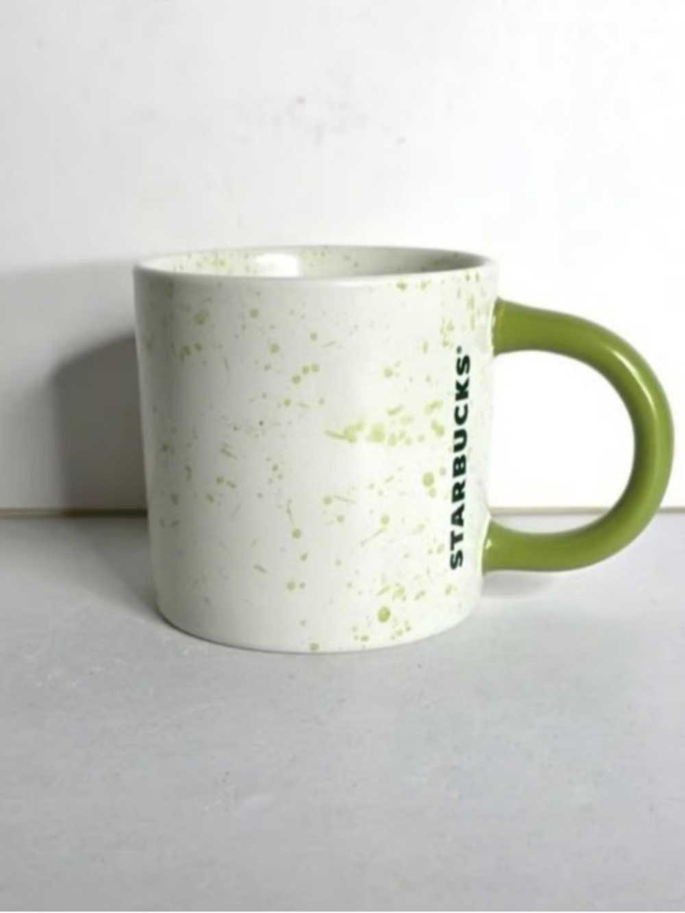 Starbucks White Ceramic Mug with Green Splatter and Green Handle